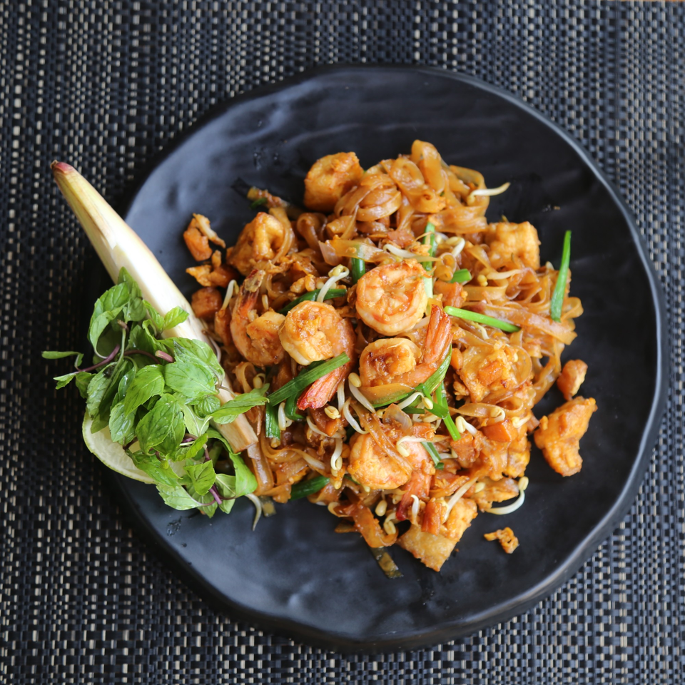 Ginger Asian Kitchen's Pad Thai with shrimp, noodles, bean sprouts, and green onions, garnished with mint.