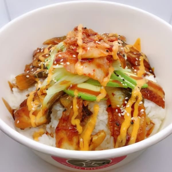 Ginger Asian Kitchen's rice bowl with eel, avocado, kimchi, and sauces, topped with sesame seeds.